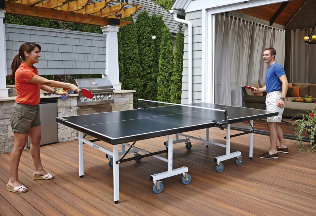 Couple playing ping pong outside
