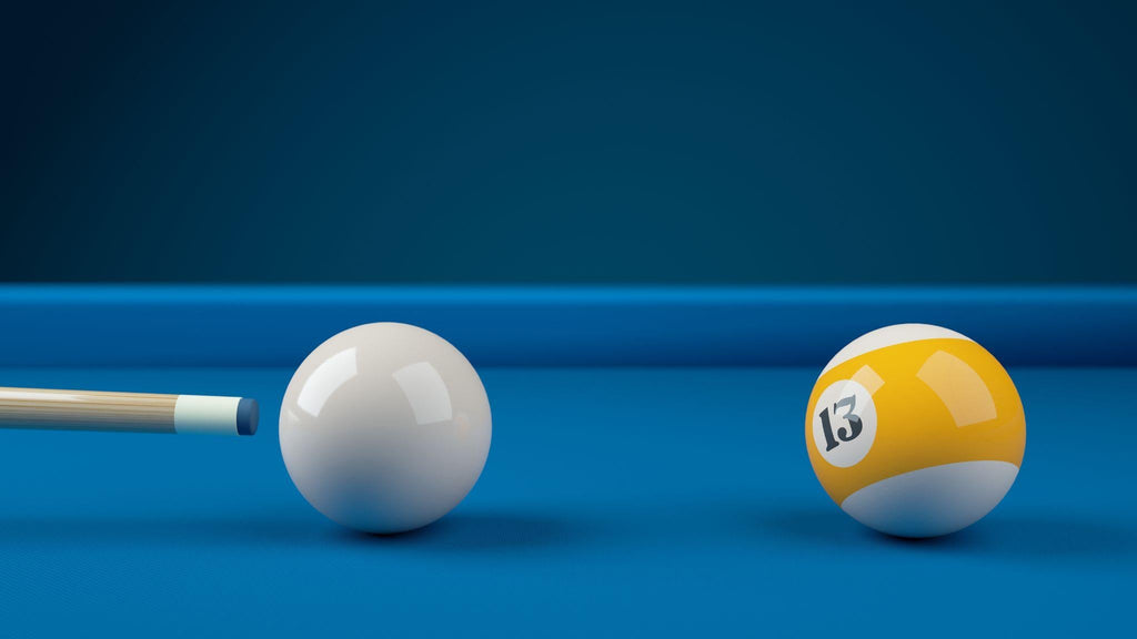 Cue ball hitting yellow number 13 ball on blue table. 
