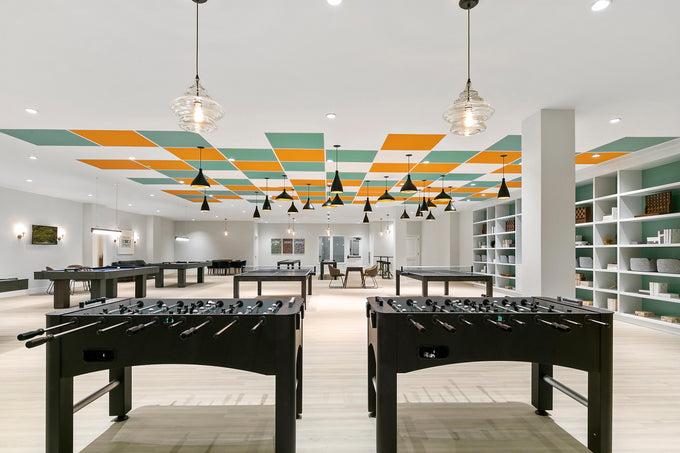 Multiple game tables in a bright lit game room.