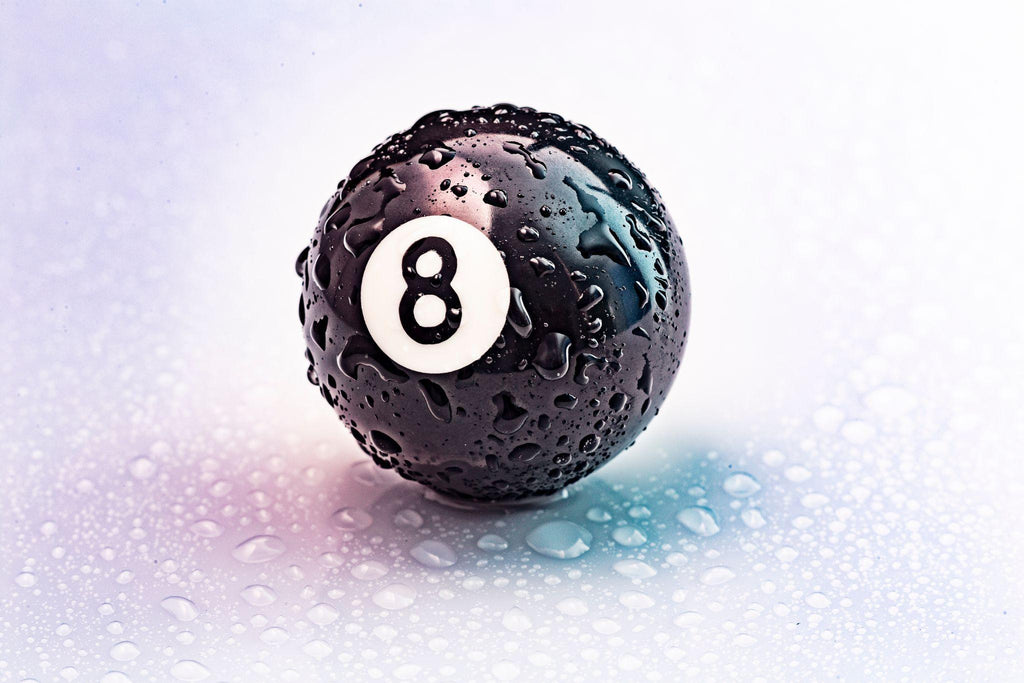 number eight pool ball with water drops on a white background