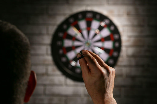 Young man playing darts indoors